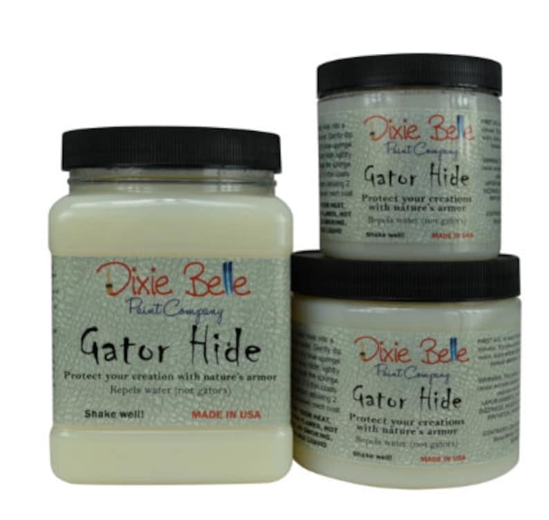 May include: Three bottles of Dixie Belle Paint Company Gator Hide protectant. The bottles are labeled with the product name and instructions to shake well. The largest bottle is labeled "Made in USA".
