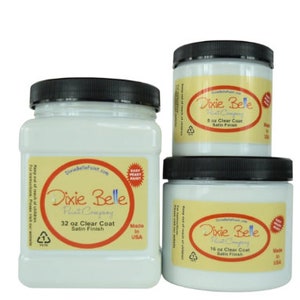 May include: Three white plastic jars of Dixie Belle Paint Company clear coat in satin finish. The jars are labeled with the size in ounces: 32 oz, 16 oz, and 8 oz.  The jars are made in the USA.