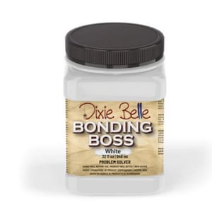 May include: A white plastic bottle of Dixie Belle Bonding Boss Problem Solver, a paint bonding agent. The bottle is 32 fl oz (946 ml) and has a brown lid.
