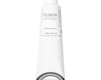 May include: White tube of Fusion Mineral Paint Brush Soap. The tube has a white pump dispenser and black and silver label with the text "Fusion Mineral Paint clean. beautiful." The tube contains 150ml or 5.06 fl oz of product.