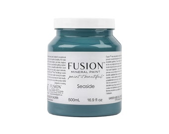 May include: A 16.9 fluid ounce bottle of Fusion Mineral Paint in the color Seaside. The bottle is blue and has a white label with the Fusion logo and the words "paint it beautiful".