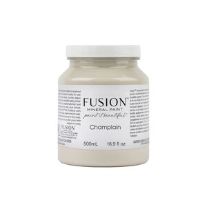 May include: A 500ml bottle of Fusion Mineral Paint in the colour Champlain. The paint is a light beige colour and the bottle is labelled with the Fusion logo and the paint colour name.
