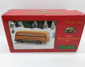 May include: A red box with a yellow school bus on the front. The box says "The Bedford Falls Bus" and "A Tribute To The Movie It's A Wonderful Life".