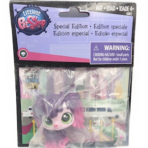 Puede incluir: Un juguete de edición especial de Littlest Pet Shop, con una figura de Stella Komondor rosa y morada. El embalaje incluye el texto "Pets in the City" y una advertencia sobre piezas pequeñas. Para mayores de 4 años.