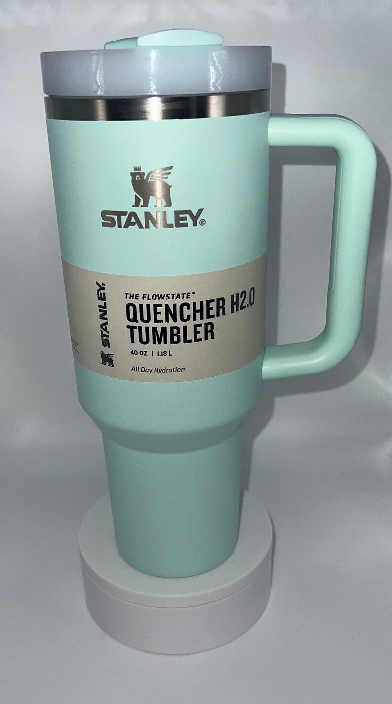 May include: A light blue stainless steel Stanley Quencher H2.0 Tumbler with a black label that reads "The Flowstate" Quencher H2.0 Tumbler, 40 oz | 1.18 L, All Day Hydration".