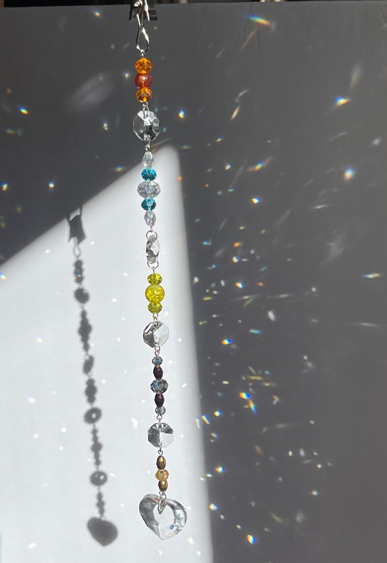 Close up showing heart prism at the end of a sun catcher strand