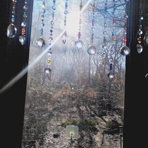 Rainbow crystal suncatcher curtain hanging in a sunlit window