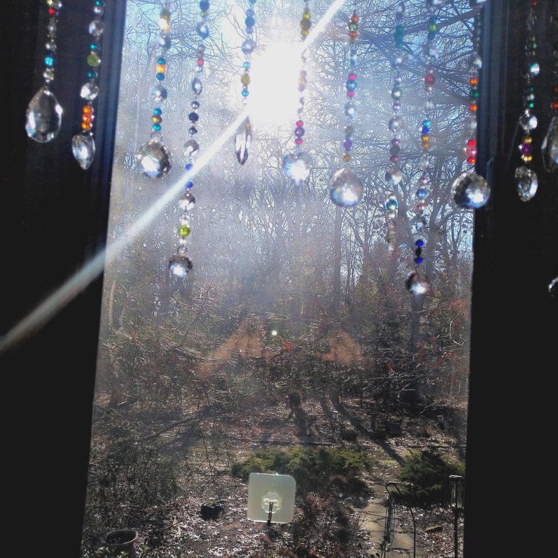 Rainbow crystal suncatcher curtain hanging in a sunlit window