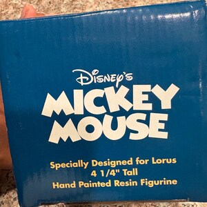 May include: A blue box with the Disney's Mickey Mouse logo in white. The text reads "Specially Designed for Lorus, 4 1/4" Tall, Hand Painted Resin Figurine."
