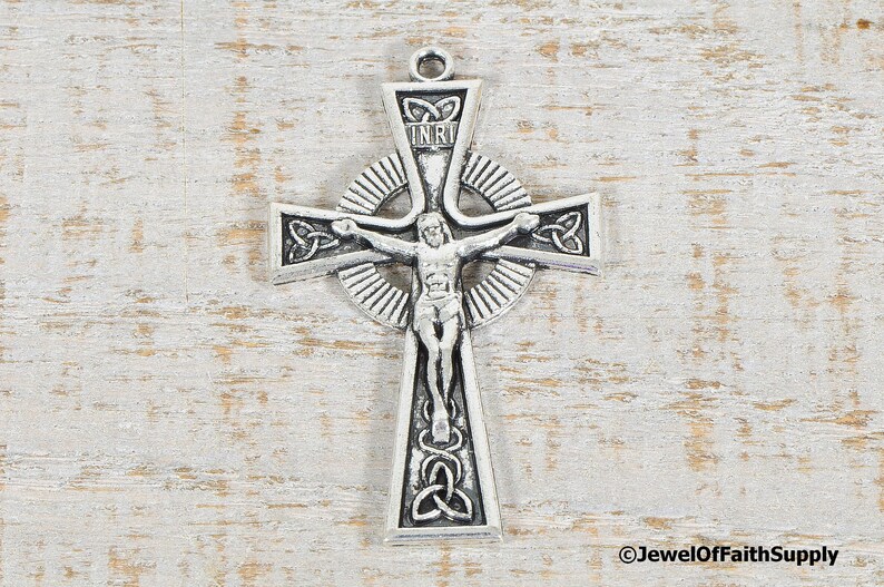 Puede incluir: Colgante de cruz celta plateado con la figura de Jesucristo. La cruz presenta intrincados dise&ntilde;os de nudos y las letras INRI. El colgante est&aacute; dise&ntilde;ado con un lazo para colgar, ideal para un collar.