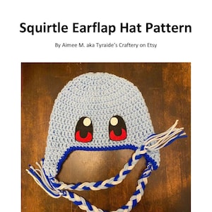 May include: A blue crocheted Squirtle earflap hat with white and blue braided ties. The hat features red and black felt eyes. Difficulty: Easy.