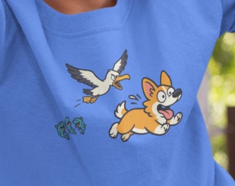 Camiseta infantil com estampa de Corgi | Cachorro de desenho animado perseguindo uma gaivota, perfeita para a praia