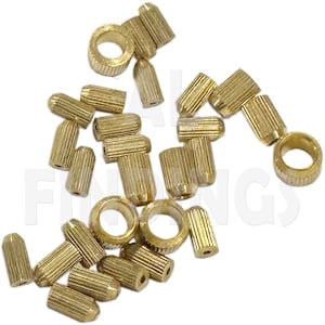 May include: A group of gold-colored metal beads, some with a cylindrical shape and others with a ring shape. The beads are used for jewelry making.