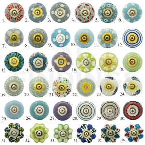 May include: Thirty-six ceramic knobs with various patterns and colours. The knobs are round and have a gold metal accent in the centre. The knobs are arranged in six rows of six.