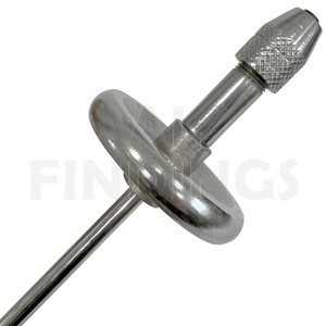 May include: A silver metal tool with a round base and a long, thin shaft. The shaft has a small, round, silver metal knob at the end. The tool is used for drilling or turning.