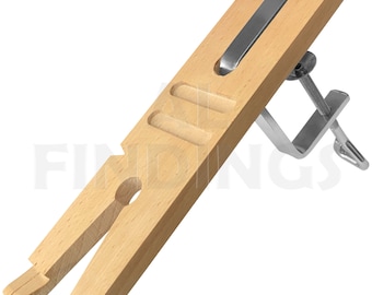 May include: A wooden ring mandrel with a metal clamp. The mandrel has three grooves for holding rings and a metal bar for tightening the clamp.
