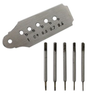 May include: A metal gauge with eight holes of different sizes, labelled 1, 0.9, 0.8, 0.7, and 0.6, and five metal drill bits.