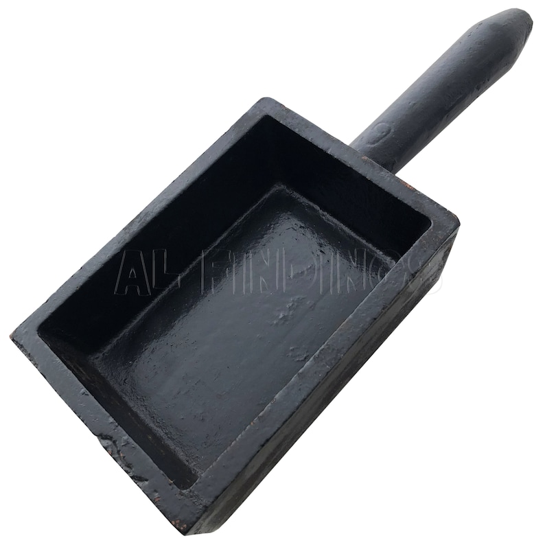 May include: A black cast iron mold with a handle. The mold is rectangular and has a smooth, shiny surface. It is designed for casting metal.