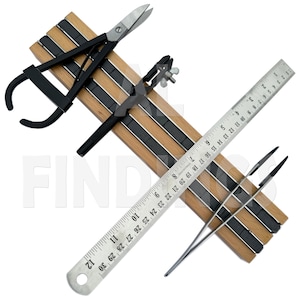 May include: A wooden magnetic tool holder with three magnetic strips. The holder has a pair of tweezers, a pair of scissors, and a ruler with markings up to 76 cm.