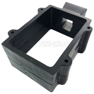 May include: Black metal casting with a rectangular opening. The casting has a small rectangular opening on the side. The casting is designed to hold a rectangular object.