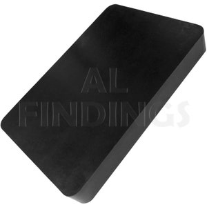 Puede incluir: Un bloque de goma rectangular negro con el texto "AL FINDINGS" en relieve en la superficie.