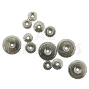 May include: A collection of silver metal watch case backs of various sizes. The case backs have a circular shape with a small hole in the center.