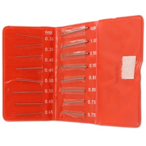 Puede incluir: Una caja de plástico roja que contiene un juego de 14 brocas. Las brocas están dispuestas en dos filas, con los tamaños etiquetados en milímetros. Los tamaños van de 0,30 mm a 1,00 mm.