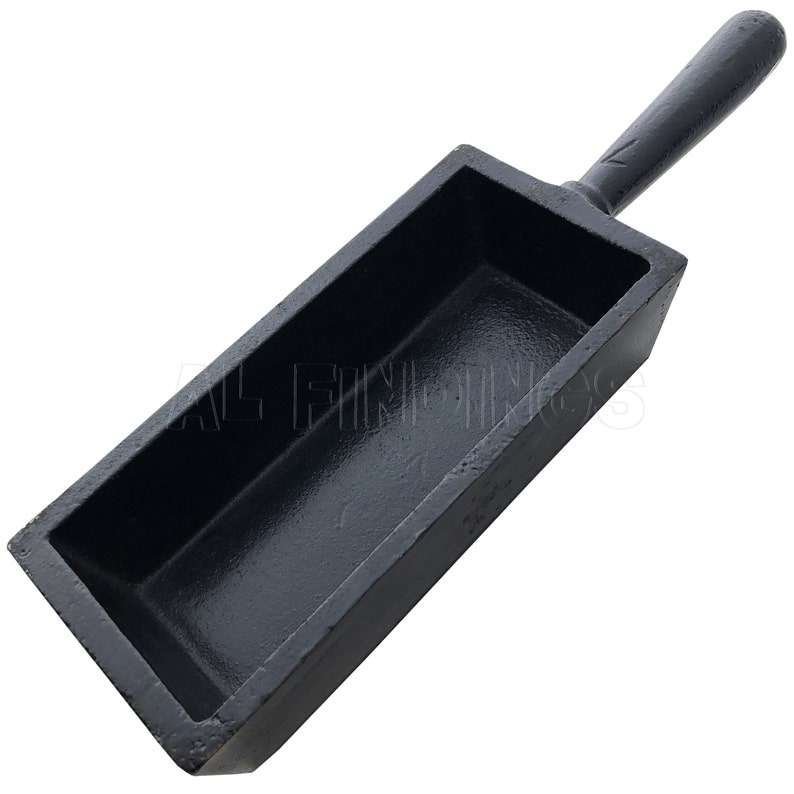 May include: Black cast iron ingot mold with a handle. The mold is rectangular with a deep cavity for pouring molten metal.