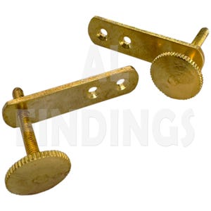 Puede incluir: Dos bisagras de metal dorado con un tornillo y una perilla en cada una. Las bisagras están diseñadas para ser fijadas a una superficie.