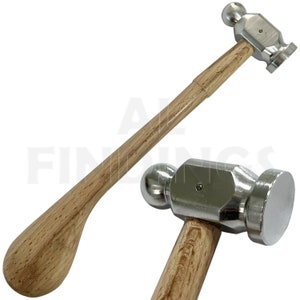 May include: A silver metal hammer with a wooden handle. The hammer has a rounded head with a flat striking surface. The handle is a light brown colour and has a rounded, spoon-shaped end.