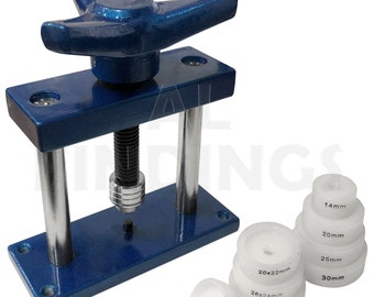 May include: A blue metal watch press with a hand crank and a set of white plastic watch case press dies. The dies are labeled with sizes in millimeters: 14mm, 20mm, 25mm, 30mm, 20x22mm, 26x24mm, 28x30mm.