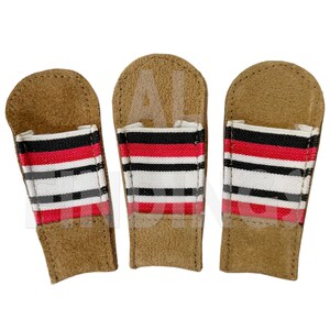 May include: Three brown leather golf club head covers with a red, black, and white striped design. The covers have a rectangular shape with a flap at the top. The covers are designed to protect golf clubs.