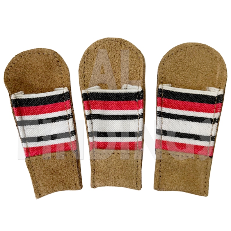 May include: Three brown leather golf club head covers with a red, black, and white striped design. The covers have a rectangular shape with a flap at the top. The covers are designed to protect golf clubs.