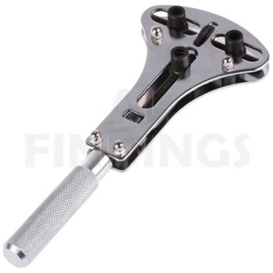 May include: A silver watch case opener with a long handle and a T-shaped head with four adjustable prongs. The prongs are black and have a rubber tip.