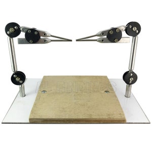 May include: A pair of adjustable soldering helping hands with a wooden base. The helping hands have two arms with adjustable clamps and a rotating base.