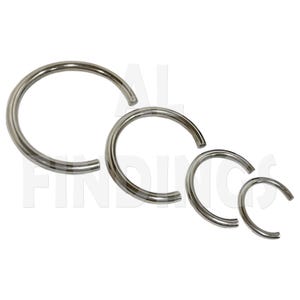 Puede incluir: Cuatro anillos metálicos plateados de diferentes tamaños sobre un fondo blanco. Los anillos son circulares, lisos y brillantes. El anillo más grande tiene aproximadamente 3,8 cm de diámetro, el más pequeño, 1,3 cm.