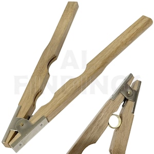 May include: A pair of wooden ring mandrels with metal clamps. The mandrels are used to size rings.