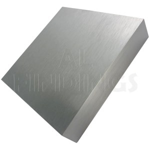 May include: A brushed silver metal block. The block is square and has a smooth, polished surface.