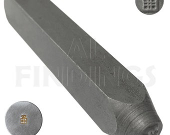 Pode incluir: Um carimbo de metal prateado com um desenho de uma caixa de presente. O carimbo é usado para criar impressões em metal ou couro.