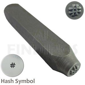 Könnte beinhalten: Ein Metallstempel mit grauer Oberfläche. Der Stempel hat einen rechteckigen Griff und einen runden Kopf. Der Kopf des Stempels ist mit einem Hash-Symbol graviert. Der Stempel wird zum Markieren von Metall verwendet.