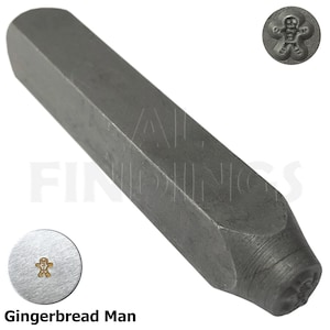 May include: A metal stamp with a gingerbread man design. The stamp is silver and has a rounded head. The stamp is used for creating impressions in metal.