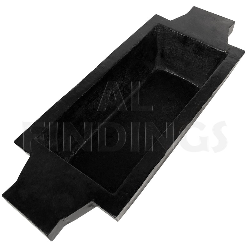 May include: Black rectangular metal mold with two handles on either end. The mold is designed for casting metal.