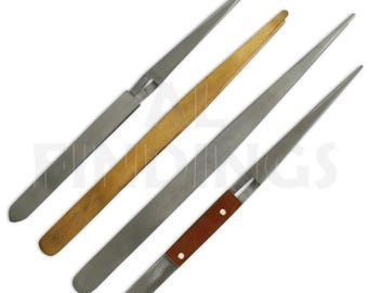 May include: Four metal tools with pointed ends. One tool has a wooden handle, another has a brown leather handle with two rivets. The other two tools are all metal. The tools are arranged diagonally.