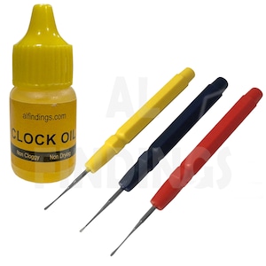 May include: A set of three watch repair tools with yellow, blue, and red handles, and a small bottle of clock oil labeled "alfindings.com CLOCK OIL Non Cloggy Non Drying".