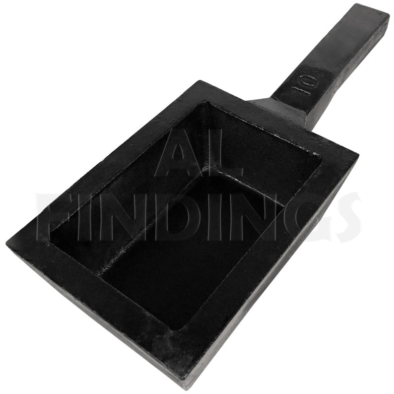 May include: Black cast iron ingot mold with a handle. The mold has a rectangular shape with a 10 inscription on the handle.
