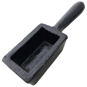 May include: Black metal casting mold with a rectangular cavity and a long handle. The mold is designed for pouring molten metal into the cavity to create a solid object.