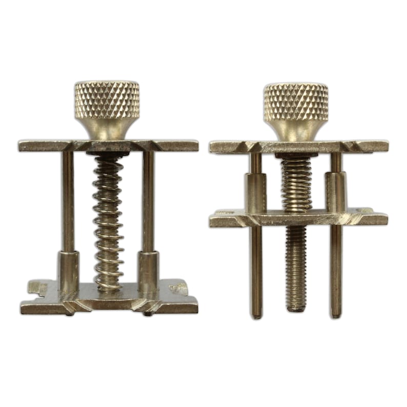 May include: Two metal watch band tools with adjustable screws and springs. The tools are used to remove and install watch bands.