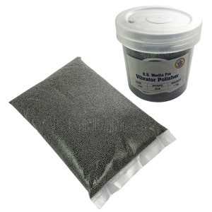 May include: A transparent plastic bag and a white plastic container filled with small, silver metal balls. The container has a white lid and a label that reads "S.S. Media For Vibrator Polisher". The bag shows the contents.