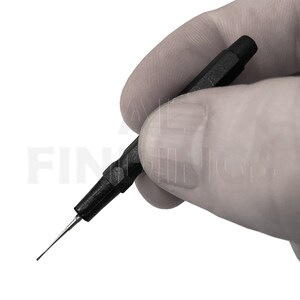 May include: A black and silver watch repair tool with a pointed tip and a black handle.