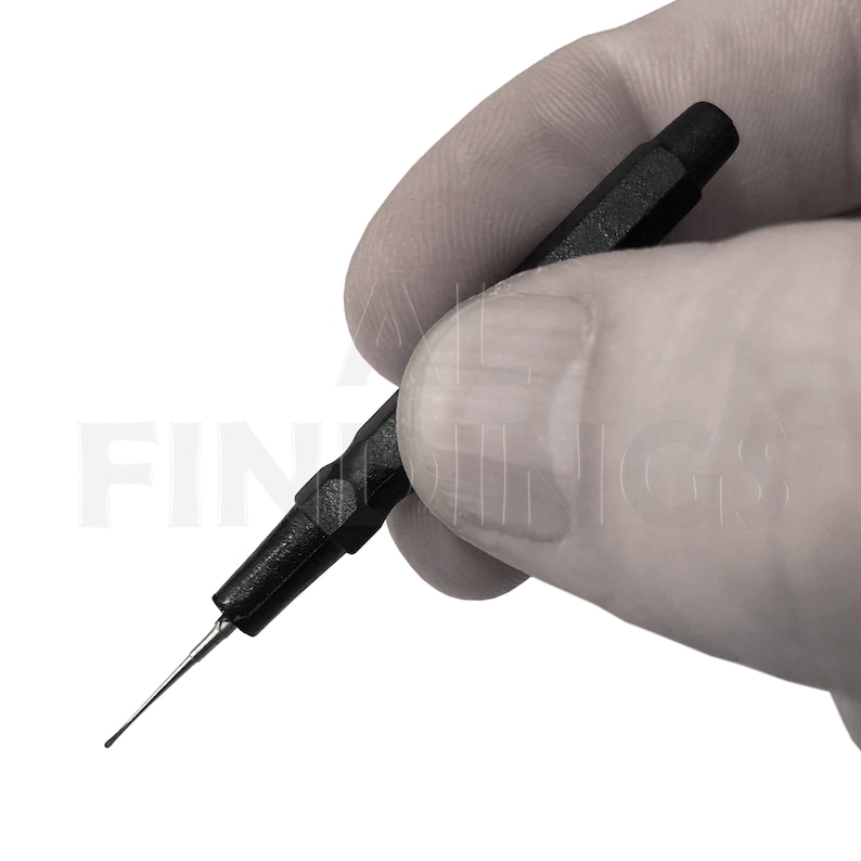 May include: A black and silver watch repair tool with a pointed tip and a black handle.